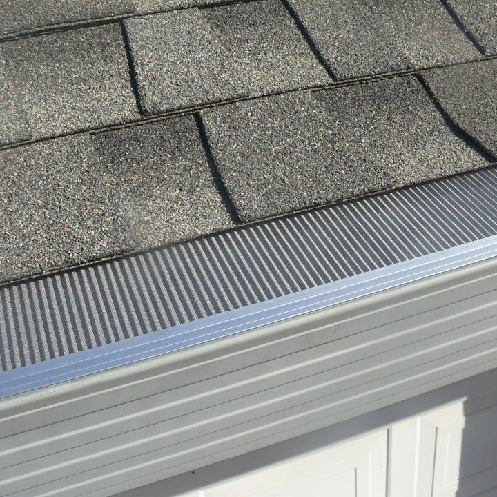 Non-combustible micro-mesh gutter guard installed along a shingled roofline